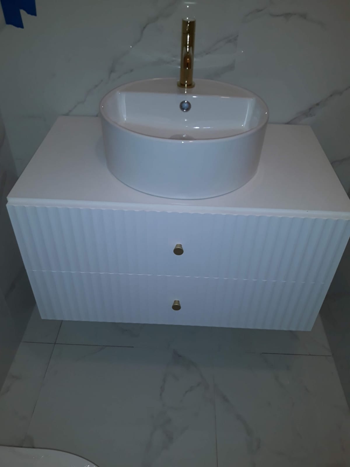 Ryflowana szafka łazienkowa ze złotymi detalami